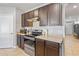Modern kitchen featuring granite counters, stainless steel appliances, wood cabinets and tile flooring at 301 St Georges Cir, Eagle Lake, FL 33839
