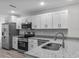 Modern kitchen showcasing stainless steel appliances, granite countertops, and white cabinetry at 302 Ave P Nw, Winter Haven, FL 33881