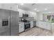 Modern kitchen featuring stainless steel appliances, granite countertops, and wood laminate flooring at 302 Ave P Nw, Winter Haven, FL 33881