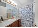 Bathroom featuring wood cabinets, a neutral countertop, and a floral shower curtain at 3137 Winchester Estates Loop, Lakeland, FL 33810