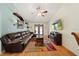 Spacious living room featuring hardwood floors, a comfortable sofa, and a ceiling fan at 3137 Winchester Estates Loop, Lakeland, FL 33810