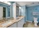 Bathroom with double sinks, granite counters, linen cabinet, and coastal decor at 3173 Sand Trap Ct, Lakeland, FL 33810