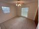 Neutral bedroom with carpet, ceiling fan, and large windows for natural light at 330 W Wellington Dr, Lakeland, FL 33813