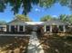 Charming brick home features a well-manicured lawn, tidy walkway, and lush foliage for great curb appeal at 330 W Wellington Dr, Lakeland, FL 33813