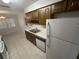 Bright kitchen area with a stainless steel sink, white appliances, and tile flooring at 330 W Wellington Dr, Lakeland, FL 33813