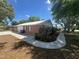 Side exterior view shows the manicured lawn and convenient sidewalk around this charming brick home at 330 W Wellington Dr, Lakeland, FL 33813