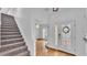 Inviting entryway featuring wood flooring, decorative front door, staircase, and views into the living area at 3919 Vista Trace Way, Lakeland, FL 33810
