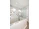 White bathroom features a walk-in shower with a clear glass enclosure and white tiles at 4189 Marseille Ln, Lakeland, FL 33810