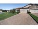 Paver driveway leads to a home with manicured landscaping and a two-car garage at 4189 Marseille Ln, Lakeland, FL 33810