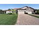 Charming home showcasing a brick driveway, a two-car garage, manicured lawn, and a stone-accented facade at 4189 Marseille Ln, Lakeland, FL 33810