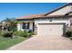 Beautiful home exterior featuring a brick driveway, landscaped front yard, and an attached two-car garage at 4189 Marseille Ln, Lakeland, FL 33810