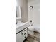 Bright bathroom featuring white shower tub combo, vanity, dark fixtures, and wood-look tile flooring at 4228 Sunny Land Dr, Lakeland, FL 33813