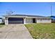 Charming single-story home with a gray exterior, updated roof, and an attached two-car garage at 4228 Sunny Land Dr, Lakeland, FL 33813