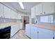 Spacious kitchen featuring stainless steel refrigerator, ample wood counter space and white cabinets with modern wood-look tile at 4228 Sunny Land Dr, Lakeland, FL 33813