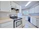 White kitchen featuring stainless steel oven and cooktop, plenty of counter space and cabinets with wood-look tile floors at 4228 Sunny Land Dr, Lakeland, FL 33813