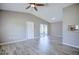 Open-plan living room featuring vaulted ceiling with fan, wood-look tile floors and sliding glass doors to screened porch at 4228 Sunny Land Dr, Lakeland, FL 33813