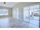 Open living area featuring wood-look tile floors and sliding glass doors leading to a screened porch with white trim at 4228 Sunny Land Dr, Lakeland, FL 33813