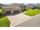 Aerial view showcasing paved driveway, three-car garage, and manicured landscaping at 5020 Truman Ln, Lakeland, FL 33812