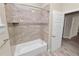 Bathroom with tiled tub and shower combination with decorative tile border and wood-look flooring at 5020 Truman Ln, Lakeland, FL 33812