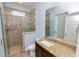 Bathroom featuring granite counters, wood-look tile, and a tiled walk-in shower at 5020 Truman Ln, Lakeland, FL 33812