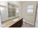 Bathroom featuring granite counters, wood cabinets, and tiled shower with wood-look flooring at 5020 Truman Ln, Lakeland, FL 33812