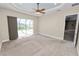 Bright bedroom with neutral carpet, tray ceiling, and sliding doors to the lanai at 5020 Truman Ln, Lakeland, FL 33812
