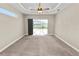 Spacious bedroom features neutral carpet, tray ceiling, and sliding doors to the lanai at 5020 Truman Ln, Lakeland, FL 33812