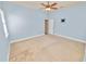 Light blue bedroom showcasing neutral carpet, ceiling fan, and walk-in closet at 5020 Truman Ln, Lakeland, FL 33812