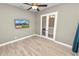 Flex space with wood-look floors, French doors and a wall-mounted television at 5020 Truman Ln, Lakeland, FL 33812