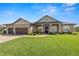 Charming single-story home with manicured lawn, a three-car garage and lovely front garden at 5020 Truman Ln, Lakeland, FL 33812