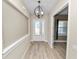 Bright foyer with wood-look floors, a modern chandelier and a view into another room at 5020 Truman Ln, Lakeland, FL 33812