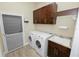 Well-equipped laundry room with washer, dryer, sink, and ample cabinet space at 5020 Truman Ln, Lakeland, FL 33812