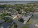 Aerial view of house in the neighborhood surrounded by mature trees, and a lake view in the background at 5432 Weber Pl, Lakeland, FL 33809