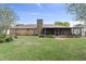 View of the backyard with a screened-in patio, mature landscaping, and a brick exterior at 5432 Weber Pl, Lakeland, FL 33809