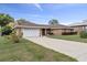 Lovely home featuring an attached garage, long driveway and mature landscaping at 5432 Weber Pl, Lakeland, FL 33809