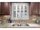 Granite countertops and wood cabinets surround a stainless steel sink in this updated kitchen at 5432 Weber Pl, Lakeland, FL 33809