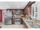 Traditional kitchen featuring granite countertops, stainless steel appliances, and dark wood cabinetry at 5432 Weber Pl, Lakeland, FL 33809