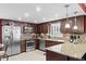 Traditional kitchen featuring granite countertops, stainless steel appliances, and dark wood cabinetry at 5432 Weber Pl, Lakeland, FL 33809