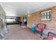 Covered patio area with brick walls, chairs and views of the back yard at 5432 Weber Pl, Lakeland, FL 33809