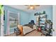 This bedroom is light blue and contains an entertainment center, bed, and window at 5883 Great Salt Ct, Lakeland, FL 33805