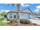Exterior of the light blue home, showcasing a three-car garage, well-maintained landscaping, and lush green lawn at 5883 Great Salt Ct, Lakeland, FL 33805