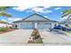 The light blue home has a spacious three-car garage with lush landscaping, offering ample parking at 5883 Great Salt Ct, Lakeland, FL 33805
