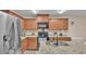 Modern kitchen with stainless steel appliances, granite countertops, wood cabinets, and black hardware at 5883 Great Salt Ct, Lakeland, FL 33805