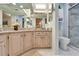 Bathroom with double sink vanity, toilet, and a glass-door shower at 6059 Condor Dr, Lakeland, FL 33809