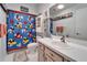 Decorated bathroom with bright Mickey Mouse shower curtain and white vanity at 6059 Condor Dr, Lakeland, FL 33809