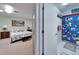 Comfortable carpeted bedroom with natural light is adjacent to a full bathroom at 6059 Condor Dr, Lakeland, FL 33809