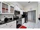 Well-lit kitchen with white cabinets, modern appliances, black countertops, and white tile flooring at 6059 Condor Dr, Lakeland, FL 33809