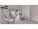 A comfortable living room features neutral tones, plush chairs, and natural light from a large window at 6059 Condor Dr, Lakeland, FL 33809