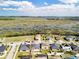 Aerial view of a residential neighborhood with well-maintained homes, green spaces, and a scenic wetland area at 661 Black Eagle Dr, Groveland, FL 34736