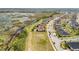 An aerial shot captures a community of homes next to a lush green wetland and a road with sparse traffic at 661 Black Eagle Dr, Groveland, FL 34736